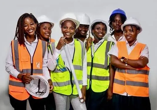 Groupe d'apprenantes en génie civil du CFIS Mbour, casques et gilets de chantier, plans à la main